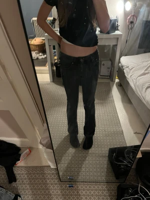 Svarta raka jeans - Säljer ett par svarta jeans med rak passform och klassisk femficksdesign. Jeansen har normal midja och stängs med knapp och dragkedja. Perfekta till en avslappnad stil och passar till det mesta. Materialet känns som bomullsdenim.