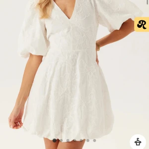 Vit kortklänning med puffärm - Supersöt vit kortklänning med v-ringning och puffiga kortärmar. Perfekt som studentklänning & helt slutsåld i storlek. Säljer det så jag tjänar 899 på det ( 50kr extra pga frakten)