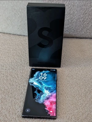 Samsung Galaxy S22 Ultra svart - Samsung Galaxy S22 Ultra smartphone i svart färg. Enheten har stor pekskärm och flera bakre kameror med blixt. Telefonen lämpar sig för vardagsbruk, surf, appar, foto och video. Levereras med originalkartong enligt bild om inget annat anges i annonsen. Se bilderna! :)