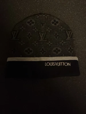 Svart och grå louis mössa med mönster. - Aldrig använt. One size fits all.