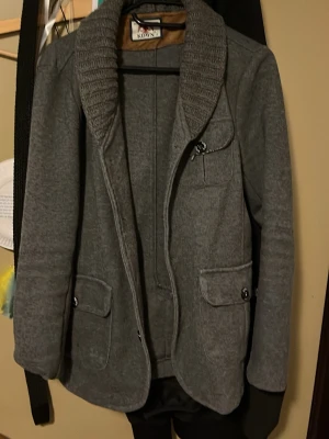 Grå kofta - Skön kofta till våren, väldigt bra skick den har inga hål eller så, hör av dig vid funderingar!