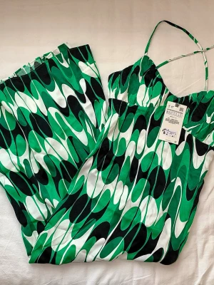 Zara satin grön/svart/vit mönstrad lång sommar klänning med öppning i storlek XS - Jättefin satinliknande lång sommarklänning med slits vid benen. Ny med prislapp och har aldrig används.  Hör av er vid fler frågor, jag svarar snabbt!