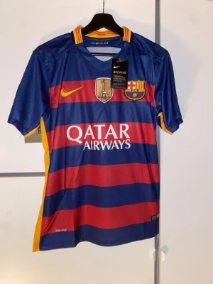 Barcelona Messi matchtröja Nike - Säljer en officiell FC Barcelona matchtröja från Nike med Messi och nummer 10 på ryggen. Tröjan har blå och röda breda ränder, gula detaljer och klubbmärke på bröstet. Skriv om du har några frågor 😀