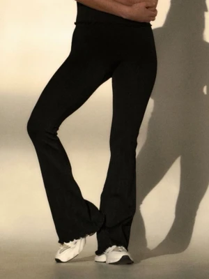 Svarta ribbade tulip leggins Aim - Säljer ett par svarta leggings med ribbad struktur och utsvängda ben. De har vågig kant längst ner och sitter tight upptill.  Np 899 kr 