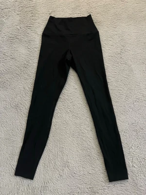 Svarta leggings från H&M Move - Säljer ett par svarta leggings från H&M Move i modellen SoftMove. De har medelhög midja och är tillverkade i ett mjukt, stretchigt material som sitter skönt på kroppen. Perfekta för träning eller chill dagar. Klassisk svart färg som passar till allt. Aldrig använda.