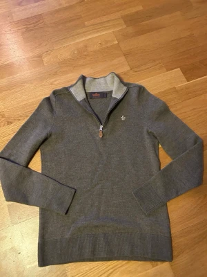 Beige/brun  halvzip-tröja från Morris S/XS - Snygg grå stickad tröja från Morris med halvzip och hög krage. Tröjan har diskret logobrodyr på bröstet och ribbade muddar vid ärmslut och nederkant. Perfekt för lager-på-lager och passar till jeans eller chinos. Jackan är i fint skick utan tecken på användning, storleken är S men har krympt i tvätten så sitter mer som en XS✅ Tröjan är i merino ull. Hör av er vid funderingar🙌