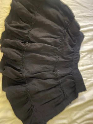 Svart volangkjol med resårmidja - Säljer en svart kortkjol med volanger och resår i midjan. 