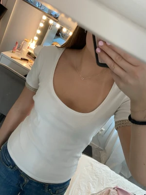 Vit tröja - Säljer en snygg vit t-shirt med guld detalj på armarna från Zara i storlek S. Fint skick, inga defekter