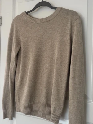 Stickad Tröja  - Lite tjockare tyg och skönt tyg, jätte fin beige färg. Använd men fint skick, finns några noppror här å där  Är märkt litet på lappen med ett S då jag har syskon☺️