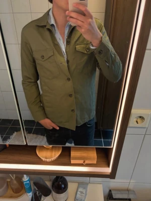Overshirt - Säljer en riktigt snygg overahirt i en linneblanning. Den är i fint skick förutom en liten vit fläck på bröstet som visas på en av bilderna                                   Modellen på bilden är 187
