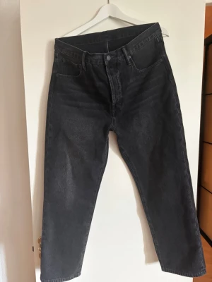 Svarta raka jeans från Acne Studios - Säljer ett par svarta raka jeans från Acne Studios. Jeansen har klassisk femficksmodell, hög midja och knappgylf. Materialet är kraftig denim i 100% bomull. Perfekta för dig som gillar en clean och tidlös look. Size 31/30