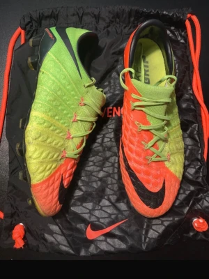 Nike Hypervenom fotbollsskor grön/orange - Säljer ett par Nike Hypervenom fotbollsskor i en riktigt fet färgkombo av neon-grönt och orange med svarta detaljer. Skorna har mönstrad ovandel för bättre bollkontroll och snörning i mitten. Perfekta för dig som vill sticka ut på planen.