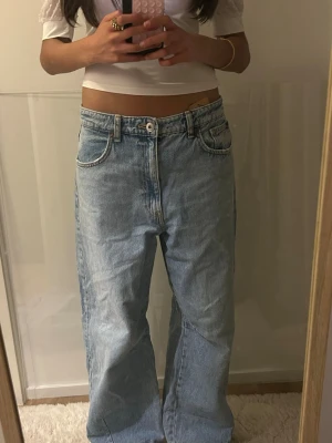 Ljusblå baggy jeans med vida ben - Populära Zara jeans, så himla snygga och trendiga. De e storlek 38 men passar 36, riktigt low waist och sitter så snyggt, passar till allting älskar dom men har så många jeans och har inte plats. Dom är helt oanvända därav priset men kan pruta , måtten är:  Innerbenslängden-73 Midjemåttet-38(76) 🩷🩷🩷  #zara #lowwaist #sthlm #wideleg #blå #jeans #skola #fest #vardag #basic