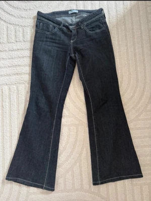Mörkblå bootcut jeans - Snygga mörkblå bootcut jeans med klassisk femficksdesign och kontrastsömmar. Jeansen har utsvängda ben och normal midja, perfekta för en trendig och avslappnad look. Tillverkade i denim med en skön passform. Har använt dom ett par gånger. 