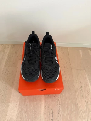 Svarta Nike Air Max sneakers - Snygga svarta Nike Air Max sneakers med vit sula och stor vit swoosh på sidan. Ovandelen är i mesh för bra andningsförmåga och skon har klassiska svarta skosnören. Luftbubbla i hälen för extra komfort och sportig look.