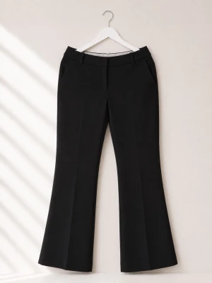Svarta bootcut kostymbyxor - Stilrena svarta kostymbyxor med bootcut passform och pressveck. Byxorna har hällor för skärp, sidfickor fram och dekorfickor bak. Perfekta för en clean och modern look. Materialet ser ut att vara en mjuk och följsam mix, troligen polyester eller viskos.