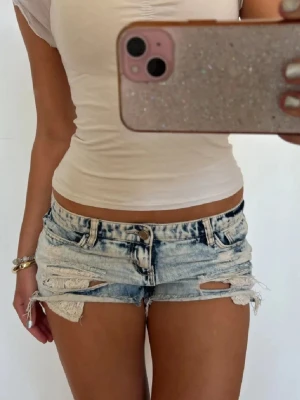 Lågmidjade slitna shorts med spets  - Såå fina ljusblå slitna lågmidjade vintage jeansshorts med spets! midjemått rakt över: 39. Jag är 168 och det är mina bilder, köp via köp nu direkt eller Swish, kvar tills markerad som såld 💖 