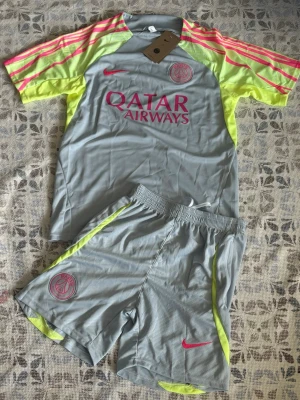 PSG träningsset grå/rosa Nike - Psg fotbollsträningsset i storlek S. Shortsen har fickor med dragkedjor. Helt nya och oanvända, perfekt till sommaren. Hör gärna av vid frågor!