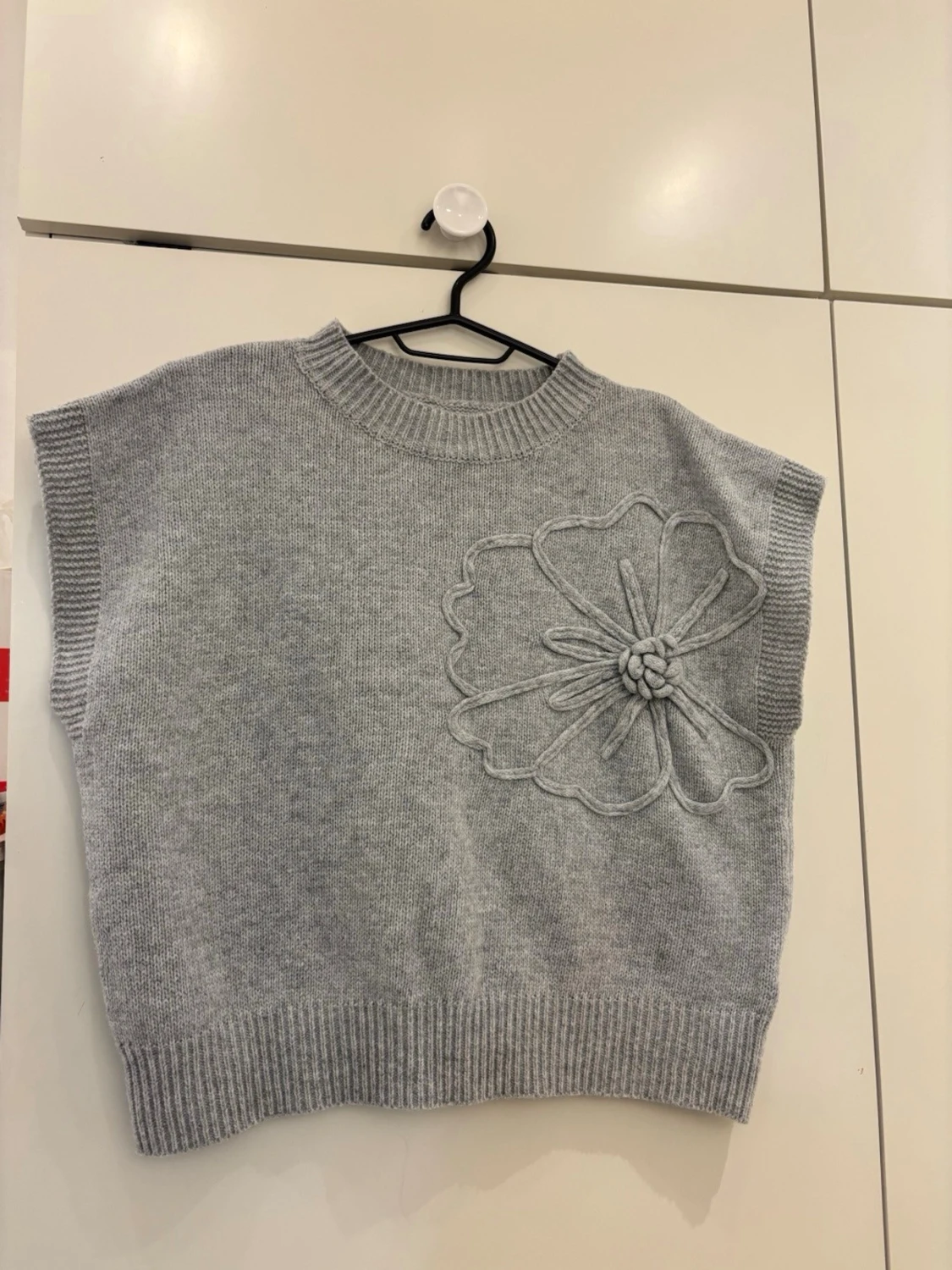 Grå stickad väst med blomdetalj - 1