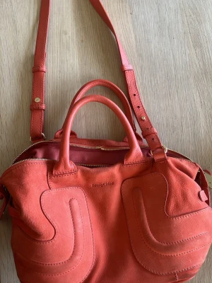 See by Chloé orange läderväska – fin satchel - Säljer fin korallröd läderväska från See by Chloé. Klassisk satchel med både handtag och axelrem. Jättefin färg som lyser upp outfits! ✨ Bra skick, äkta läder med guld detaljer. Perfekt vardag eller fest. . Frågor eller önskas fler bilder så skriv gärna! Kan skickas snabbt 😊