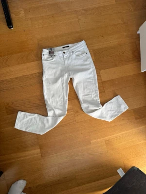 Vita slim fit jeans nudie jeans - Snygga vita slim  jeans från nudie jeans.  W29-l30 . klassisk femficksdesign och slim passform. Jeansen har normal midja och är tillverkade i ett stretchigt material för extra komfort. Perfekta att matcha med en riktig fet sommar outfit till sommarn🤩