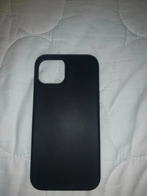 Svart mobilskal från JETech - iPhone 12/13/14 - Stilrent svart mobilskal från JETech med slät yta och stor öppning för kameran. Skalet är gjort i ett tåligt material som skyddar mobilen mot repor och stötar. Passar perfekt för dig som vill ha ett enkelt och snyggt skydd till din telefon.