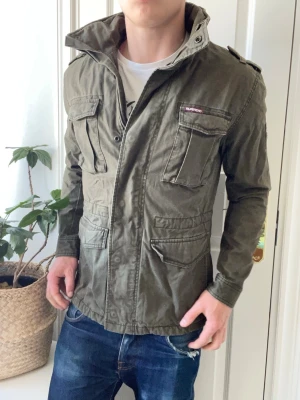 Superdry fieldjacket  - Superdry fieldjacket - lätt fodrad. Inget tjockt direkt, Inga defekter! Modellen i bilderna är 180 cm 75 kg och bär Storlek M , Kom med frågor! 🌟 (Kan gå ned i pris vid köp av paket 😉) 