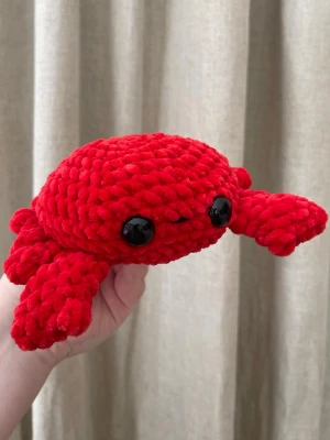 Handvirkad krabba i chenillegarn - Handvirkad krabba i mjukt chenillegarn. Ca 17 cm bred. Mjuk och formstabil med noggrant virkade detaljer. Passar som present eller som en unik inredningsdetalj. Helt handgjord.