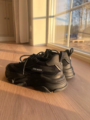 Sneakers Steve Madden - Aldrig använda. Svarta chunky sneakers från Steve Madden med kraftig sula och meshdetaljer. Skorna har en modern design med svarta snören och logga på sidan. Perfekta för dig som gillar streetstyle och vill sticka ut med en cool look.
