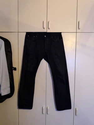 Levi's jeans 501 - Säljer ett par svarta jeans från Levi's med klassisk med raka ben. Modell 501. Storlek w34 L32. Litet hål i bakfickan se bild 