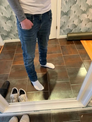 Replay anbass jeans - Säljer ett par klassiska blå slim fit jeans från Replay med fem fickor och snygga sömmar. Jeansen har normal midja och är tillverkade i denim med lätt stretch för skön passform. De är ”aged 1 year”. Bara att skriva vid funderingar😊
