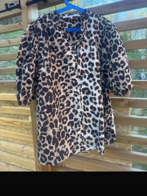 Leopardmönstrad blus Second Female - Snygg leopardmönstrad blus från Second Female i storlek M. Blusen har puffiga korta ärmar och knäppning framtill. Tillverkad i ett lätt och mjukt tyg som ger en skön känsla. Perfekt för dig som vill sticka ut med ett trendigt djurmönster. Kommer inte till användning hemma längre.