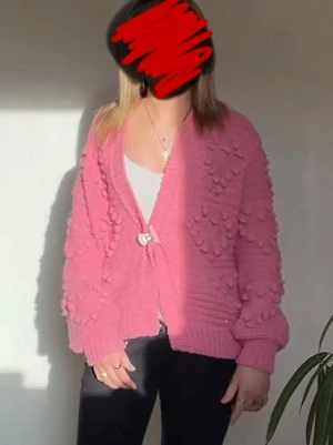 Rosa kofta från River Island XS - Säljer en rosa stickad kofta från River Island i storlek XS. Koftan har ett unikt bubbelmönster och en dekorativ hjärtformad knäppning framtill. Mjuk och skön med ribbade muddar på ärmar och nederkant. Perfekt för att liva upp din outfit!