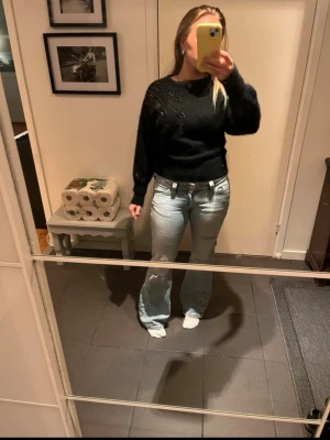 Svart stickad tröja med pärldetaljer - Superfin unik svart tröja med pärlbroderi längs med axeln.