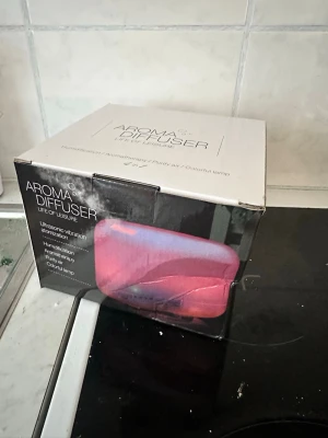Aroma Diffuser med fjärrkontroll - Aroma Diffuser från Life of Leisure i vit färg med fjärrkontroll och strömadapter. Diffusorn har ultrasonisk vibration, luftfuktare, aromfunktion och färgad lampa. Perfekt för att sprida doft och skapa en avslappnande atmosfär hemma. Diffuser   Luftfuktare. 