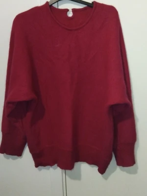  Mörkrosa stickad tröja med rund hals - Mysig mörkrosa stickad tröja med rund halsringning och långa ärmar. Tröjan har ribbstickade muddar vid ärmslut och nederkant. Perfekt för kyliga dagar och enkel att matcha med jeans eller kjol.
