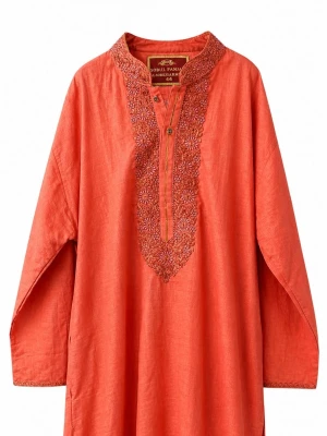 Indisk Orange långklänning med broderi - En orange långklänning med långa ärmar och vackert broderad detalj framtill vid halsen. Klänningen har slitsar i sidorna och en avslappnad passform, perfekt för varma dagar. Tillverkad i ett lätt och luftigt material.