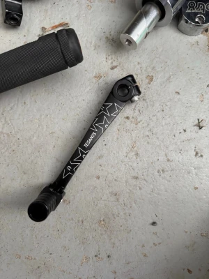 Svart vevarm  - Säljer en svart vevarm med vita grafiska mönster. Tillverkad i metall och passar till cykel. Snygg och stilren design med tydlig logga på sidan. Perfekt för dig som vill uppgradera din cykel med något unikt.