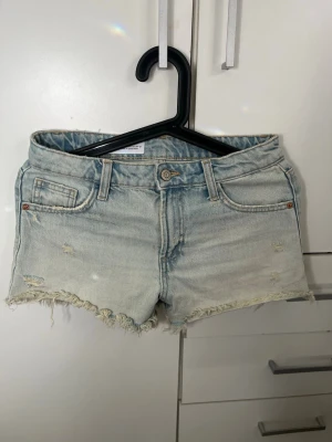Ljusblå jeansshorts med fransig kant - Säljer ett par ljusblå denimshorts från Zara. Inga effekter. Storlek 32 och midjemått rakt över är 35cm! 💕 
