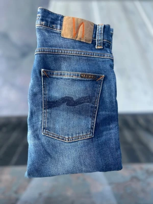 Nudie jeans grim Tim  - Ett par rikigt feta nudie med en extremt snygg tvätt👖storlek 30/32 Model grim Tim  Inga defekter eller hål✅ Mått: 40cm bred i midjan, 102cm långa! Tveka inte på att skriva om ni är intresserade eller har några frågor☺️