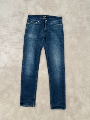 Blå slim fit jeans från BLK DNM W30 L32 - Snygga blå slim fit jeans från BLK DNM med klassisk femficksdesign och diskreta slitningar framtill. Jeansen har normal midja, dragkedjegylf och är tillverkade i mjukt denimtyg som ger en bekväm känsla hela dagen. 