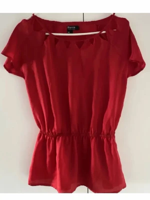 Röd topp strl XS - Denna topp/blus är så himla fin! Härlig röd färg och funkar lika väl i vardagen som festligare tillfällen. Köpt på Blanco i Spanien, det står xs i den men tycker den passar xs-s