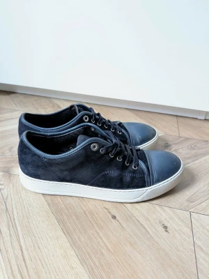 Lanvin DBB1 - Tja, säljer ett par sparsamt använda Lanvins i modellen DBB1. Dom är marinblåa i storlek 8 UK samt i skick omkring 7/10. För mer information hör av dig! Mvh Adam