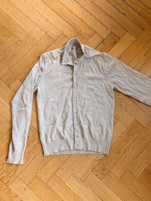 Ljusbeige cardigan Stenströms - Klassisk beige cardigan från Stenströms med långa ärmar och knäppning framtill. Tillverkad i kashmir. Perfekt för lager på lager och enkel att matcha med olika outfits. Storlek M men lite kort i längden så skulle säga att den passar med som S. Fint skick förutom höger arm som har två symärken ifrån hål. Detta syns knappt vid användning. Hör av er vid frågor och funderingar!