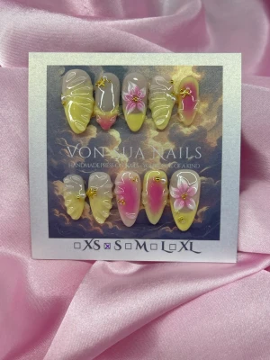 Blossom (S);Medium Almond - Unika handgjorda press-on naglar i en medium lång mandelform med en mix av pastellgul och rosa färg. Dekorerade med handgjord 3D-blommor, 3D linjer och små guldfärgade detaljer. Perfekta för dig som vill ha en kreativ och färgstark nagelstil. S: 15 mm, 11,5 mm, 12 mm, 11 mm, 9 mm 