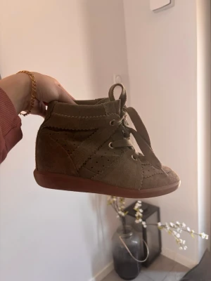 Isabel Marant skor intressekoll - Snygga gröna mockaskor från Isabel Marant med snörning och perforerade detaljer. Skorna har en kilklack och är perfekta för en stilren look. De är tillverkade i mjuk mocka och har en bekväm passform.😍