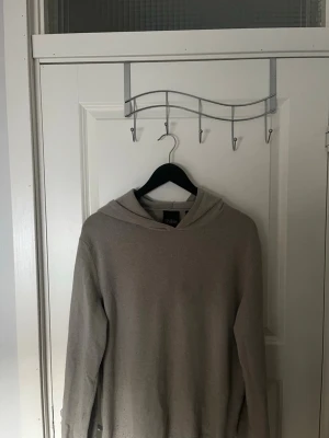 Kashmir hoddie från Oscar Jacobson  - Mjuk och lyxig beige hoodie i kashmir med lång ärm. Perfekt för en avslappnad och stilren look. Klassisk huva och enkel design utan synliga detaljer. 100% Kashmir från Oscar Jacobson