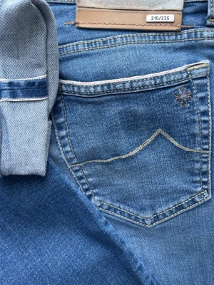 Jacob Cohen Nick LTD – Limited Edition (210/235) – Selvedge - Unika Selvedge Jacob Cohen Nick Limited Edition i en ljus sällsynt tvätt. Handgjorda i Italien i högsta kvalité. 🧵 JC - Nick LTD. 📏 W34, Slim Fit. 🧩 92% Bomull, 6% Elastomultiester, 2% Elastan. 📐 Midja: 42,5cm. Längd: 101cm. Benslut: 17cm. Lår: 26cm. ✅ B Grade. Fint skick. Använda men med mycket liv kvar. ✨ Selvedge, numrerad (210/235), lyxiga knappar, brodyr och Certilogo-äkthetsintyg. 💰 Nypris på dessa ligger runt 6500 kr. Fråga gärna vid minsta tanke, fler bilder elr dylikt‼️ Skickas snabbt ‼️ 