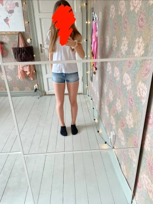 Ljusblå denimshorts  - Snygga ljusblå denimshorts med spetskant och klassisk femficksdesign. Shortsen har en tight passform och är perfekta för varma sommardagar. De är tillverkade i bomull och har en enkel, stilren look utan mönster. Står ingen storlek men uppskattar att det är xs eller en liten S sitter tajt på mig som brukar ha S eller M. 