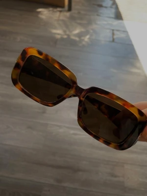 GG glasögon - Säljer ett par bruna, mönstrade solglasögon. De har en rejäl båge som känns lyxig. På sidan sitter G logga i guld. Väldigt fin modell som passar till allt. 
